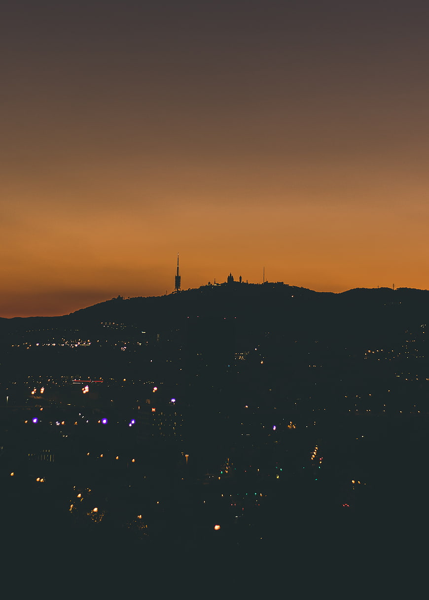 Silhouette of Barcelona skyline at sunset with city lights