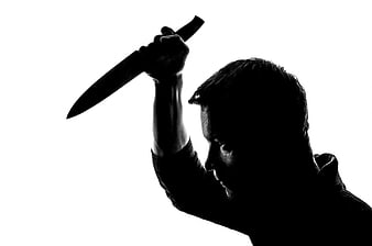Silhouette of man holding knife raised high