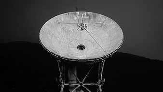 Black and White Satellite Dish Against Dark Sky