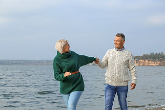 Happy Senior Couple Holding Hands by the Sea