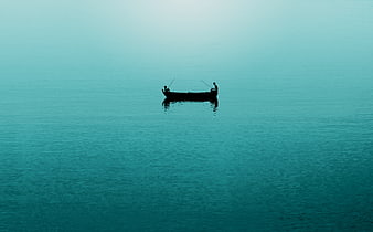 Silhouette of two fishermen in a boat on calm teal water