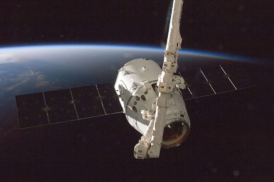 Spacecraft with solar panels orbiting Earth in space
