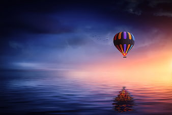 Colorful Hot Air Balloon Floating Over Calm Ocean at Sunset