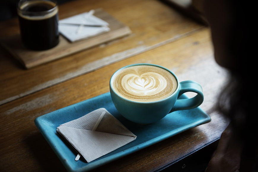 Blue Cup of Cappuccino with Heart Latte Art on Wooden Table