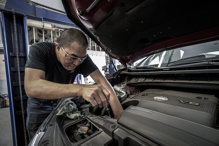 Automotive Mechanic Performing Engine Maintenance In Auto Repair Shop
