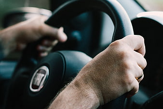Close-up of hands gripping a car steering wheel