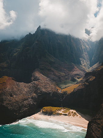 Dramatic coastal landscape with hidden beach and misty mountains