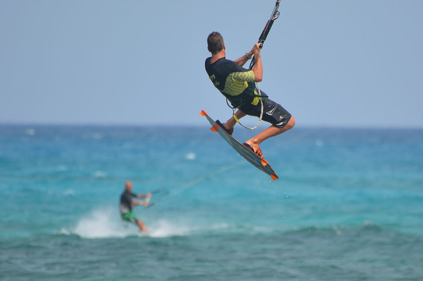 Kitesurfer Jumping High Over Blue Ocean Waves
