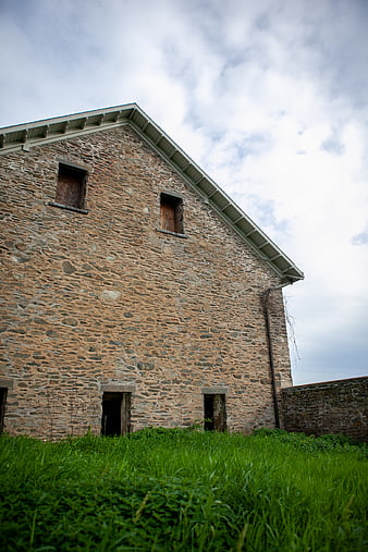 Old Stone Building Facade with Overgrown Grass