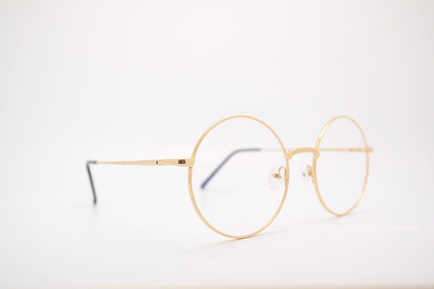 Gold round metal eyeglasses on white background