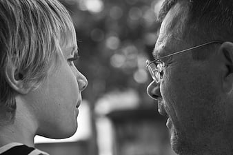 Black and white profile portrait of a father and son in conversation