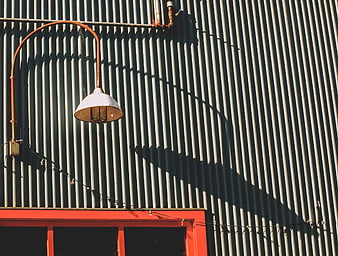 Industrial Lamp on Corrugated Metal Wall with Shadows