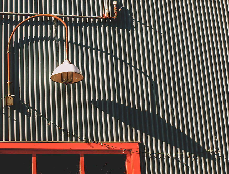 Industrial Lamp on Corrugated Metal Wall with Shadows