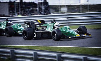 Vintage green Formula 1 race cars speeding on track