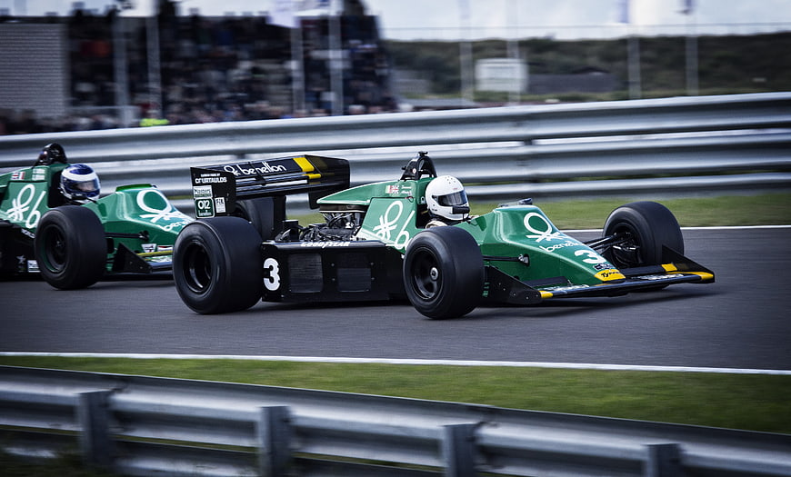 Vintage green Formula 1 race cars speeding on track