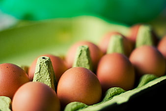 Close-up of brown eggs in a green carton