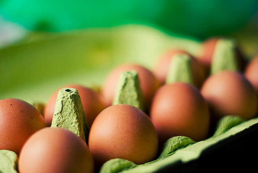 Close-up of brown eggs in a green carton