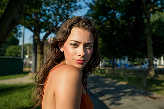 Portrait of young woman in park looking back