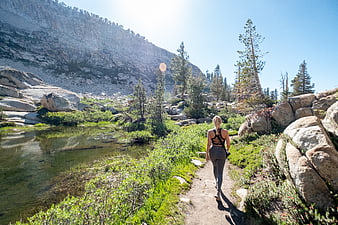 Woman hiking on mountain trail near alpine lake