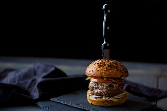 Gourmet beef burger slider with knife on dark slate