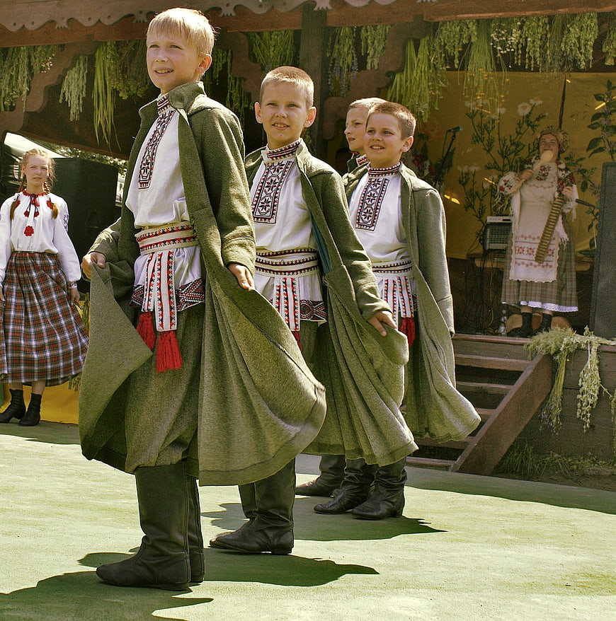 Young boys in traditional folk costumes performing a dance