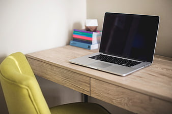 Modern workspace with laptop on wooden desk and yellow chair