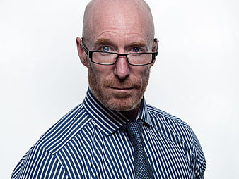Professional Portrait of Bald Man With Glasses And Blue Striped Shirt