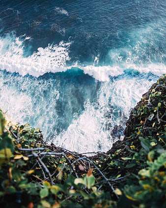 Aerial View of Crashing Ocean Waves Against Rocky Cliff