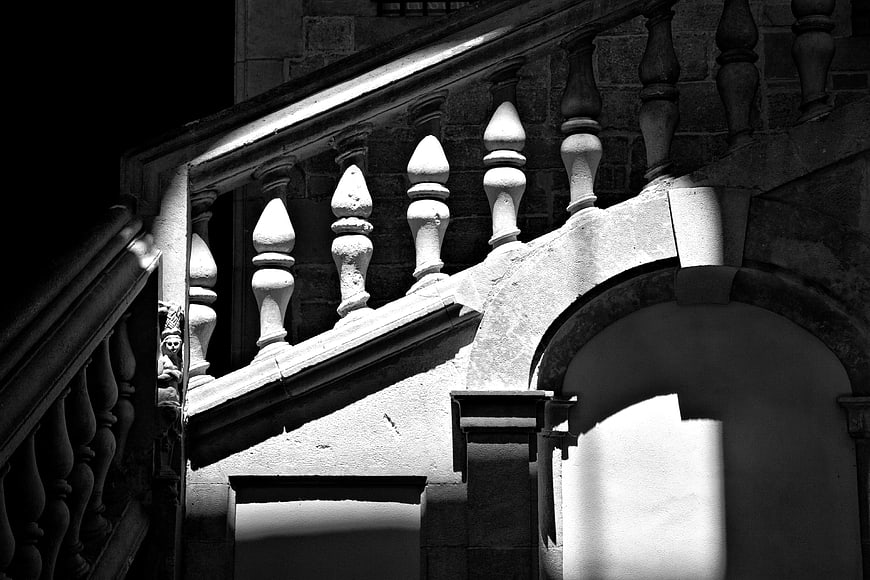 Black and white architectural detail of stone balustrade and archway