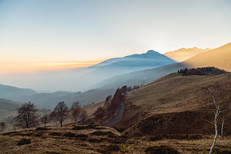 Misty Mountain Landscape with Winding Road at Sunset