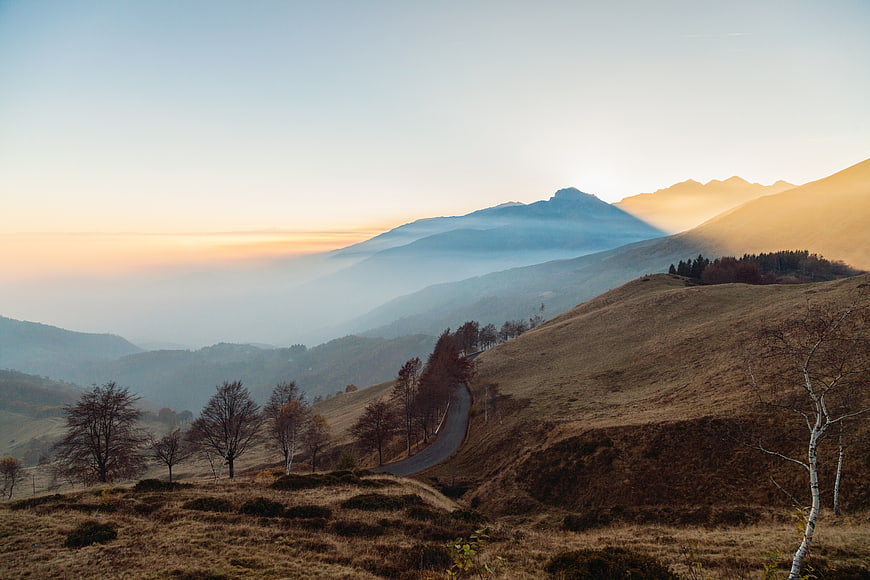 Misty Mountain Landscape with Winding Road at Sunset