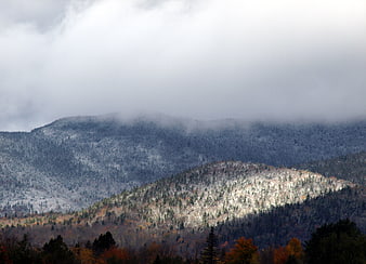 Snowy Mountain Peaks with Autumn Foliage and Clouds