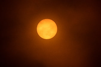 Glowing orange sun in a hazy dark sky