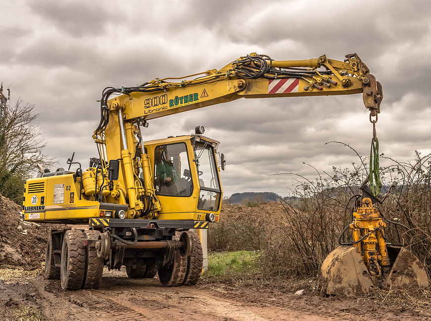 Yellow Liebherr excavator with hydraulic gripper on construction site