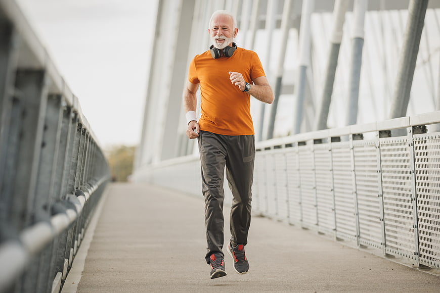 Active Senior Man Running on Modern Bridge
