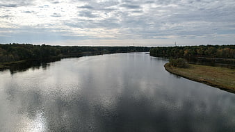 Aerial view of calm river winding through autumn forest
