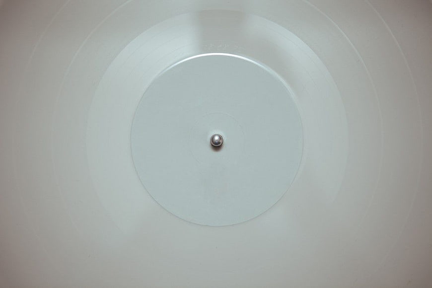 Minimalist white vinyl record with silver spindle