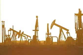 Silhouetted Oil Pumping Units In Desert At Golden Hour