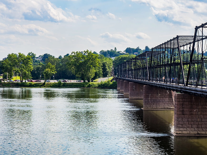 Historic Iron Truss Bridge Over River with Green Trees