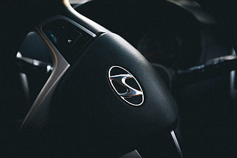Close-up of Hyundai steering wheel logo in car interior