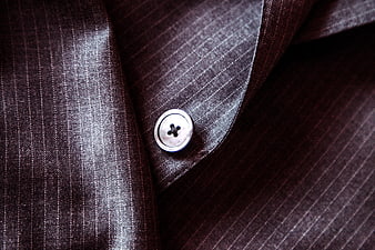 Close-up of dark pinstripe suit fabric with silver button