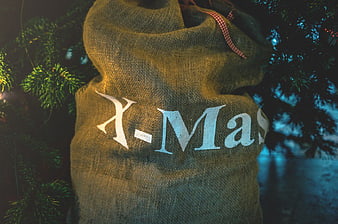Burlap Santa Sack with X-Mas Text Under Christmas Tree