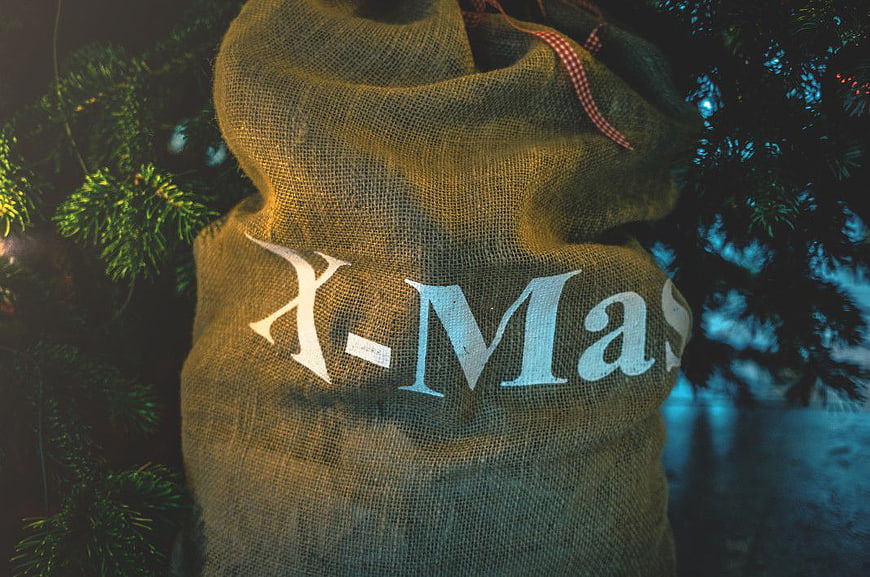 Burlap Santa Sack with X-Mas Text Under Christmas Tree