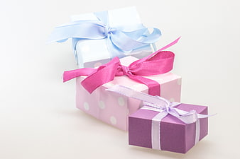 Three pastel gift boxes with ribbons on white background