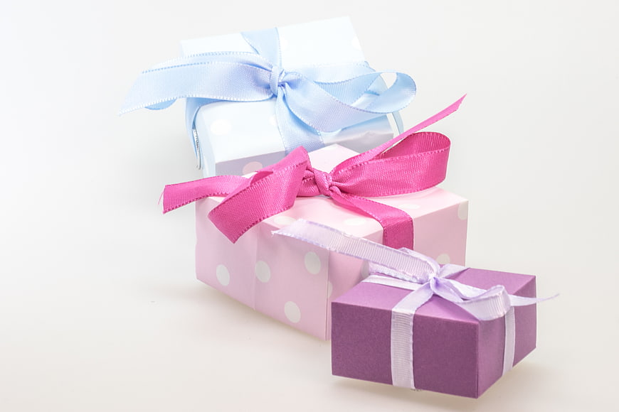 Three pastel gift boxes with ribbons on white background