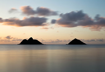 Serene Sunset Silhouette of Islands Over Smooth Ocean