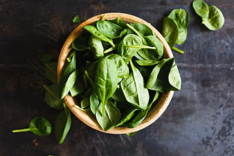 Fresh Spinach Leaves in Wooden Bowl on Dark Background
