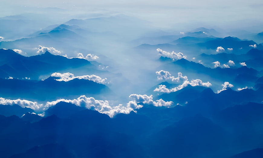Majestic Blue Mountain Range with Clouds and Mist