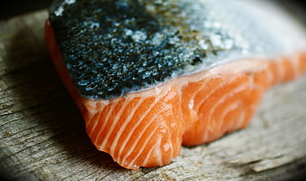 Fresh raw salmon fillet with skin on rustic wooden board