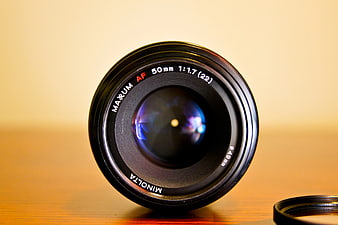 Close-up of Minolta 50mm Camera Lens on Wooden Table